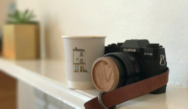 A camera and cup sitting on the mantle of someone's home.